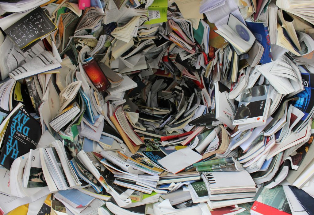 A whirlwind of books and papers creating a chaotic visual. Ideal for concepts of disorder or information overload.
